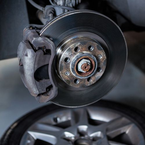Bremsscheibe und Bremssattel an einem aufgebockten Fahrzeug